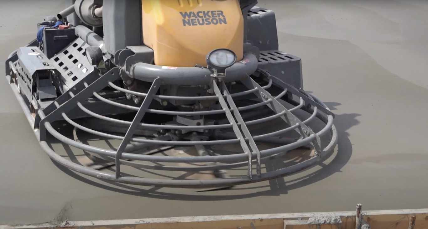 Professional power trowel finishing commercial concrete surface in Metairie, LA