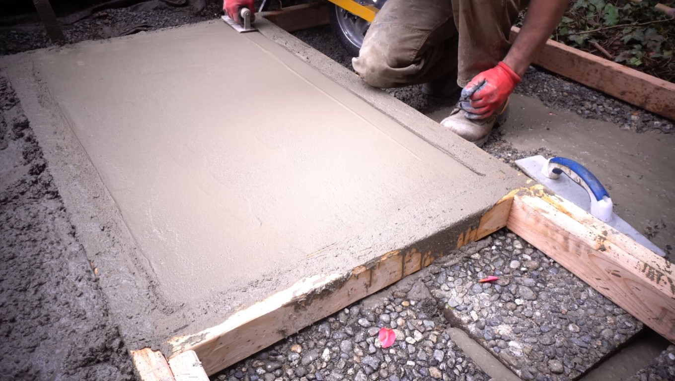Skilled concrete worker carefully hand-finishing concrete surface in Metairie, LA
